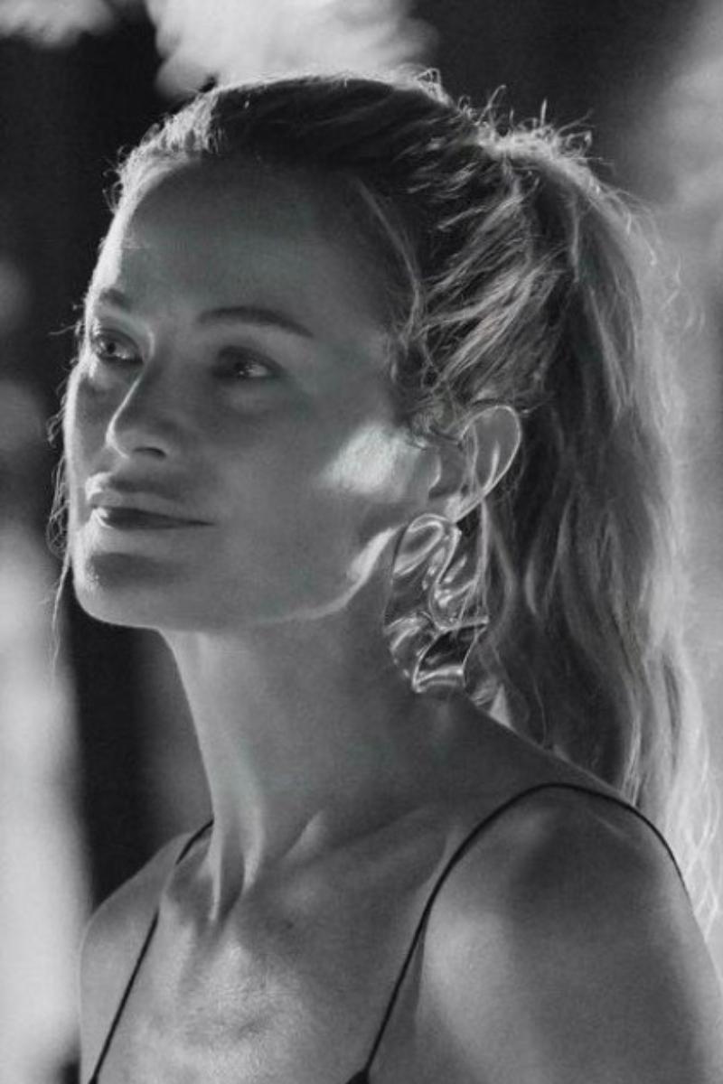 model carolyn murphy wears sculptural gold earrings.