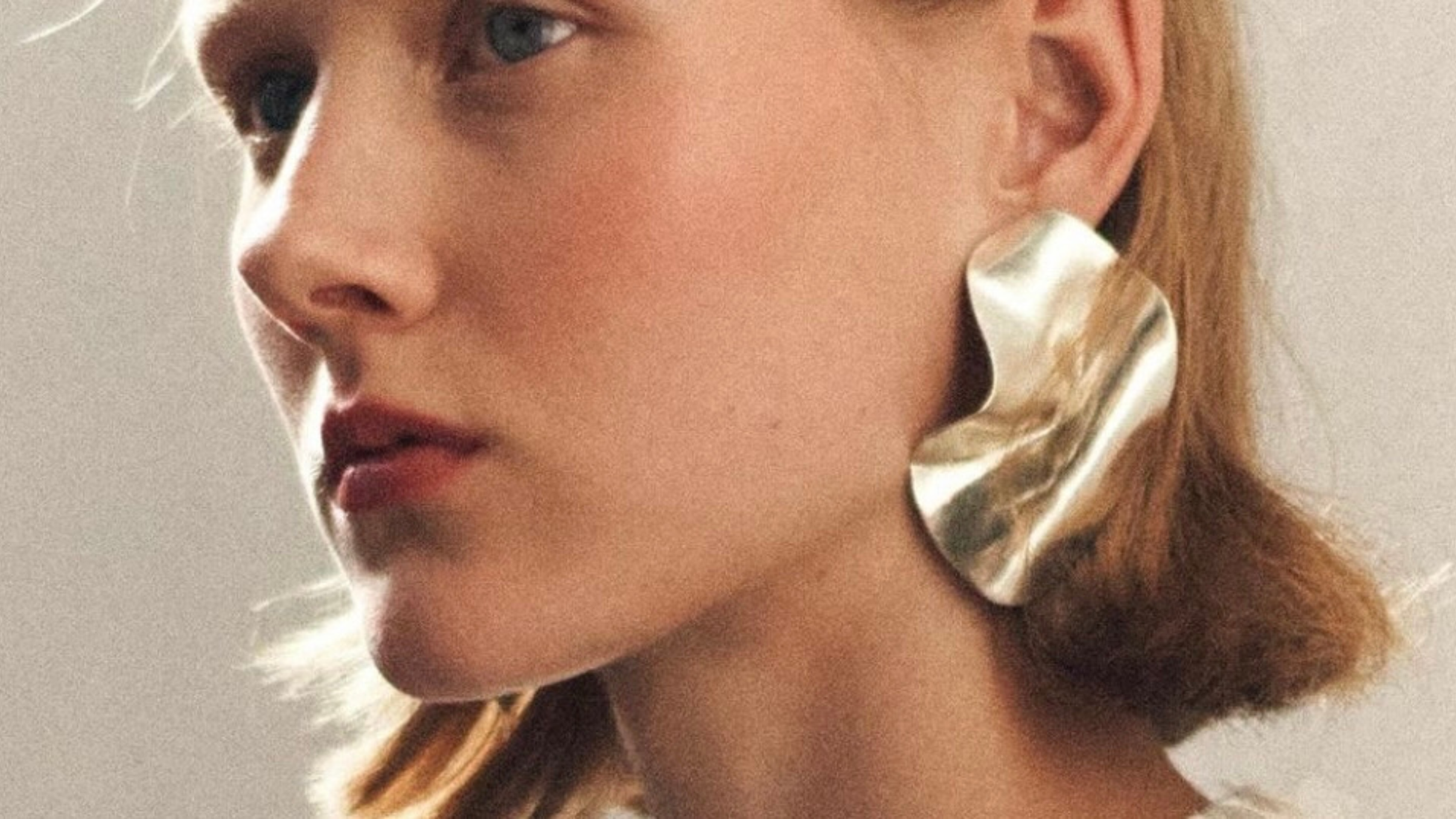 model wears sculptural silver earrings at london fashion week.